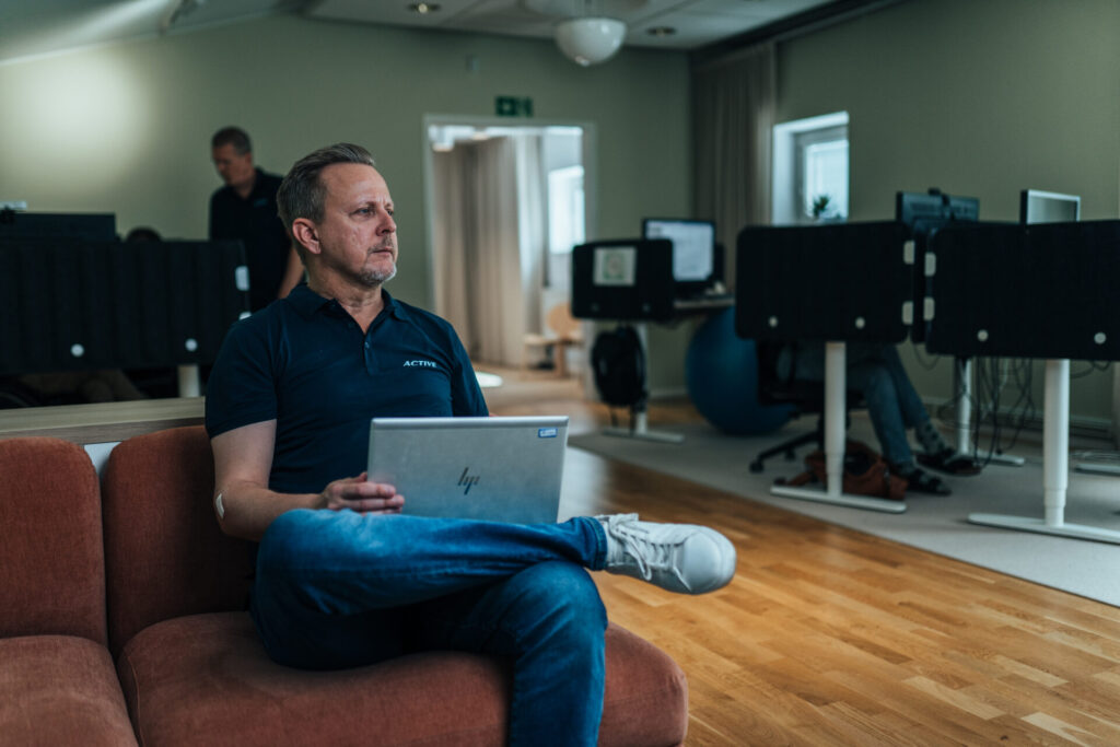 Active IT-medarbetare sitter med en bärbar dator i kontorsmiljö